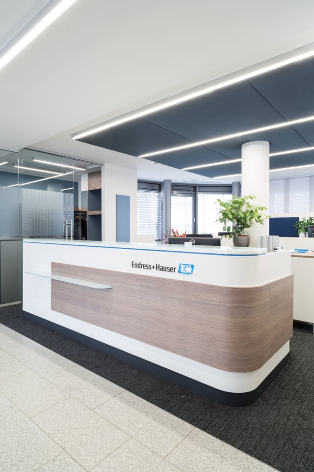 Empfangstheke in Weiß und Holzoptik mit dem Schriftzug Endress+Hauser