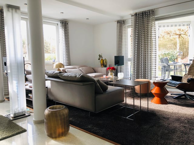 Wohnzimmer mit Sofa, Säulen, gestreiften Vorhängen und Blick in den Garten