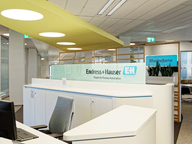 Empfangstheke mit dem Schriftzug Endress+Hauser unter einem gelben Deckenfeld