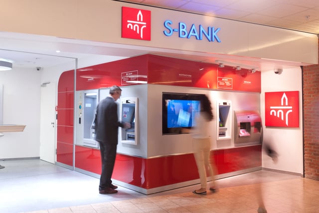 Selbstbedienungsbereich mit Automaten in roter Verkleidung unter dem Schriftzug „S-Bank“